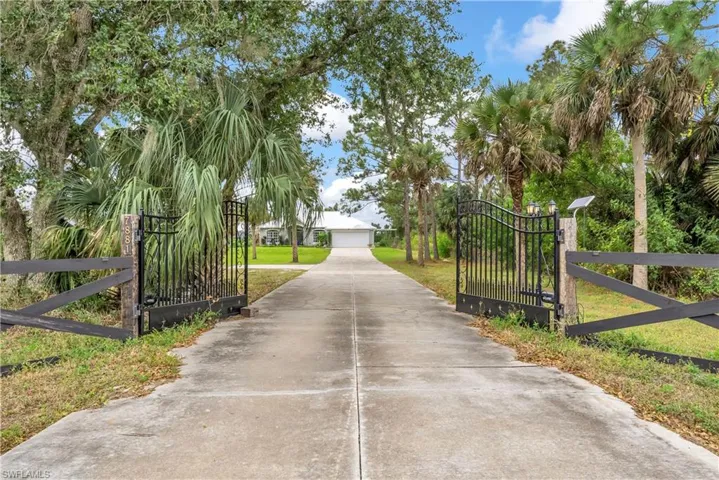Surrounding community featuring a gate, a garage, and concrete driveway