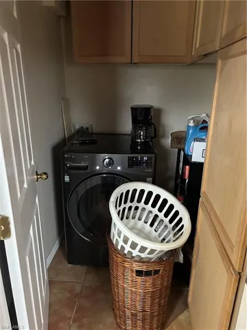 Laundry room featuring washer / clothes dryer and light tile patterned flooring