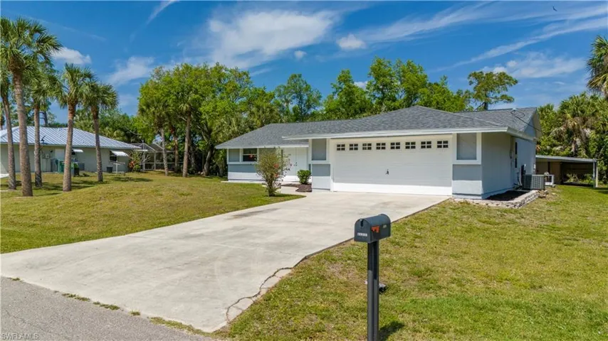 Ranch-style home featuring a garage and a front lawn