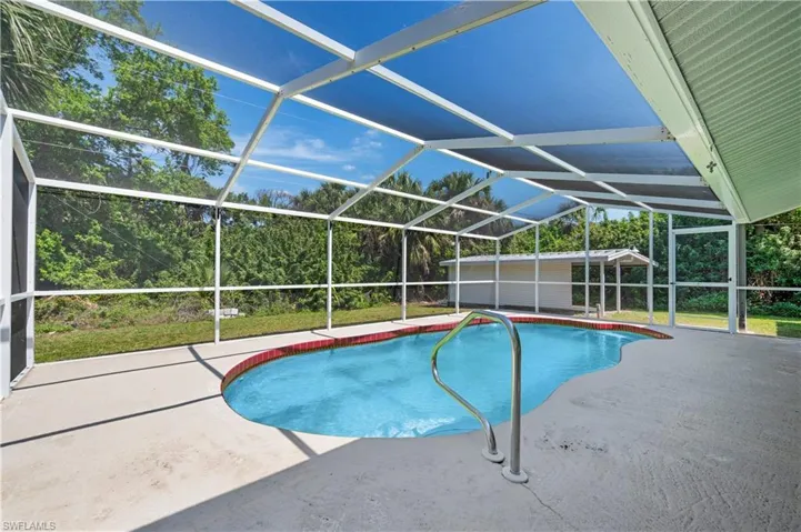 View of swimming pool featuring a lanai and a patio area