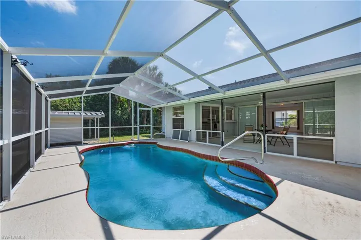 View of pool with a patio and screened enclosure
