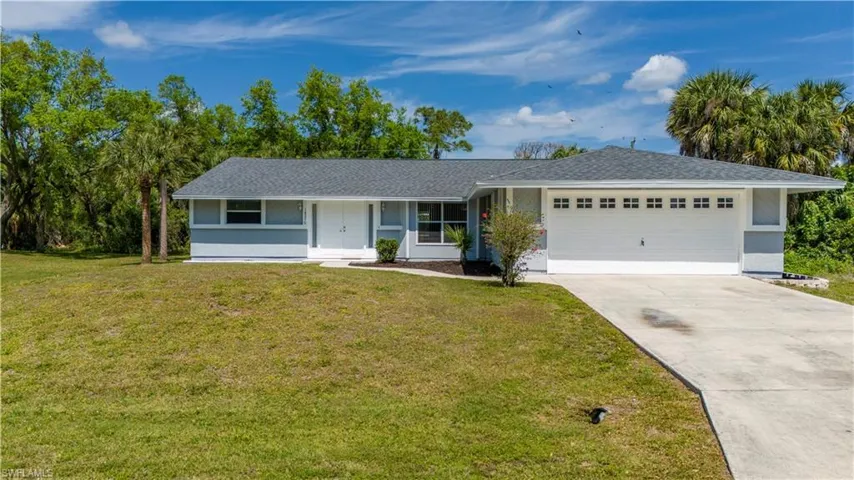 Ranch-style home featuring a garage and a front yard