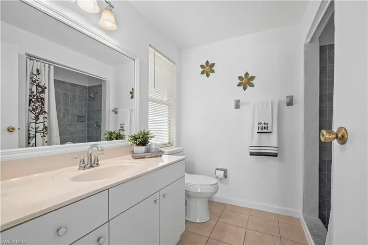 Primary Bathroom featuring tile flooring, toilet, and vanity