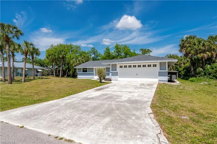 Ranch-style home with a garage and a front lawn
