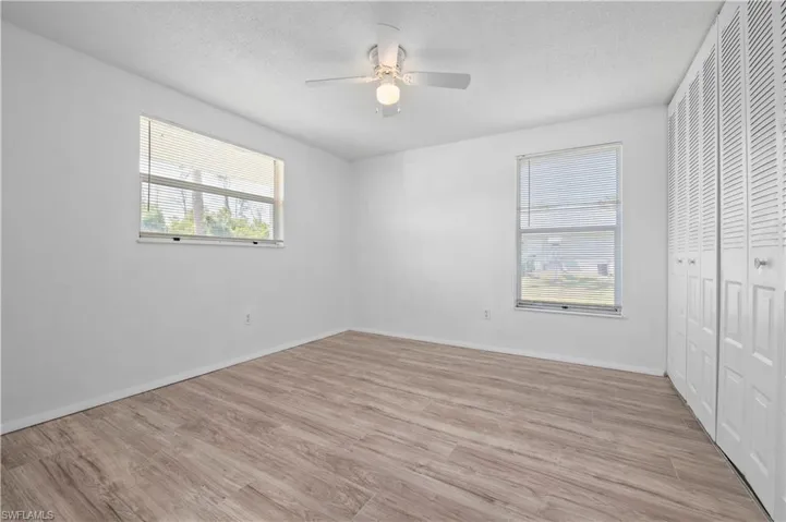 Unfurnished bedroom featuring a textured ceiling, ceiling fan, and light wood-type flooring