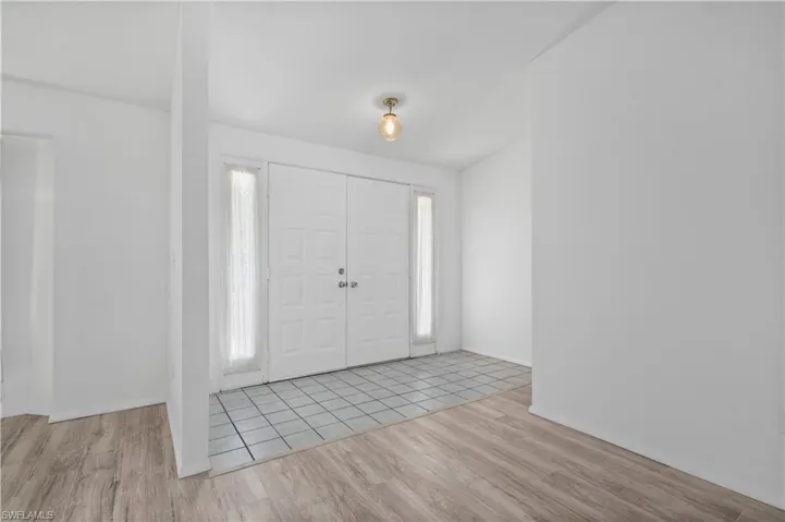 Entrance foyer with light hardwood / wood-style floors and a healthy amount of sunlight