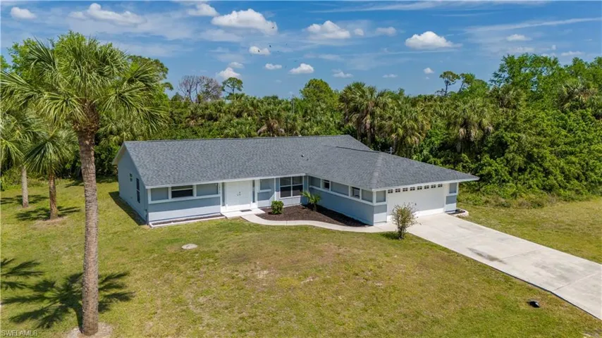 Single story home with a front yard and a garage