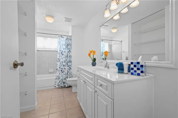Full bathroom featuring shower / bathtub combination with curtain, tile flooring, plenty of natural light, and vanity