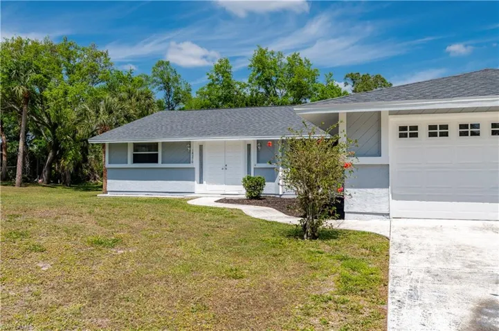 Ranch-style home with a front lawn and a garage