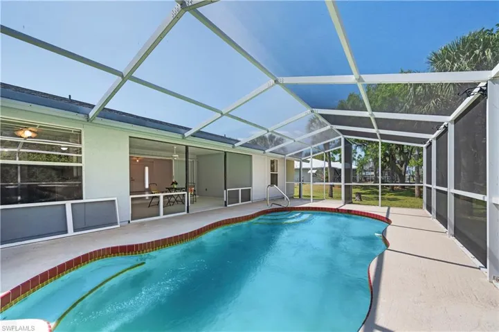 View of swimming pool featuring a lanai and a patio