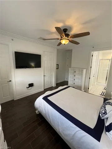 Bedroom featuring crown molding, wood finish floors, and ceiling fan