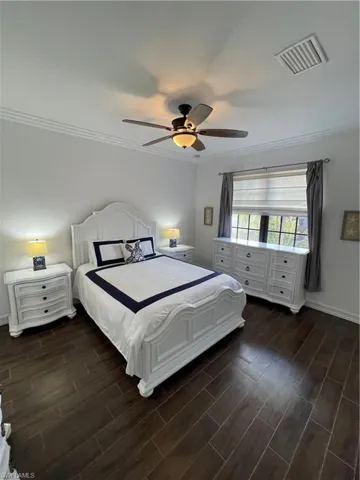 Bedroom featuring wood finish floors, crown molding, and ceiling fan