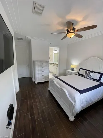 Bedroom featuring wood tiled floors, a ceiling fan, ornamental molding, and ensuite bathroom