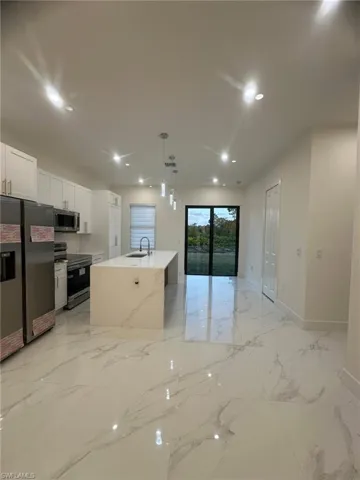 Kitchen featuring marble finish floor, pendant lighting, a sink, recessed lighting, and appliances with stainless steel finishes