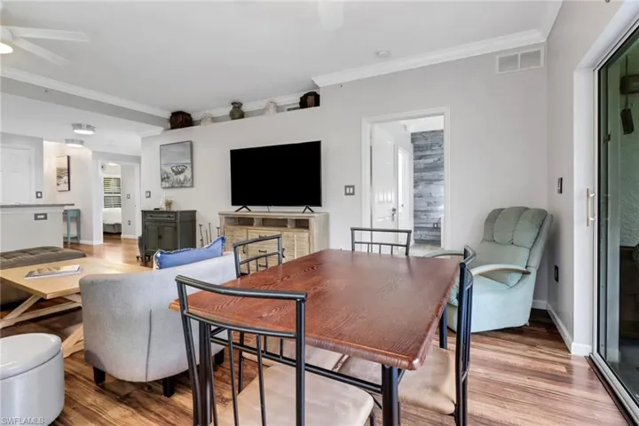 Dining room featuring ceiling fan, wood finished floors, ornamental molding, and baseboards