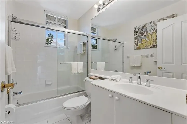 Full bathroom featuring vanity, toilet, bath / shower combo with glass door, and tile patterned floors