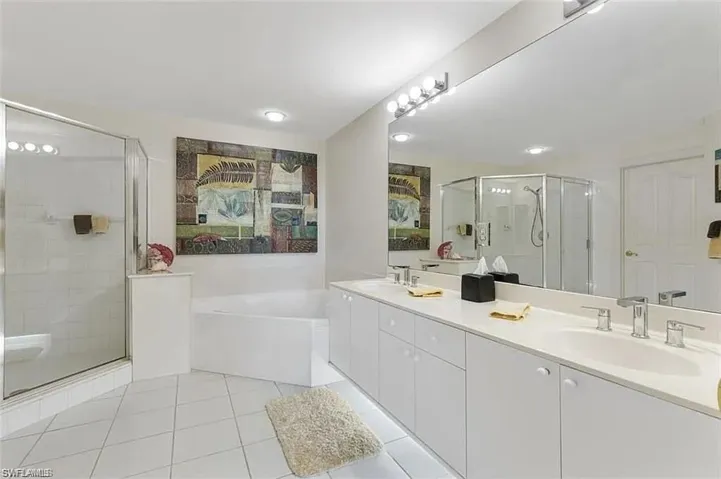 Bathroom with tile patterned floors, independent shower and bath, and vanity