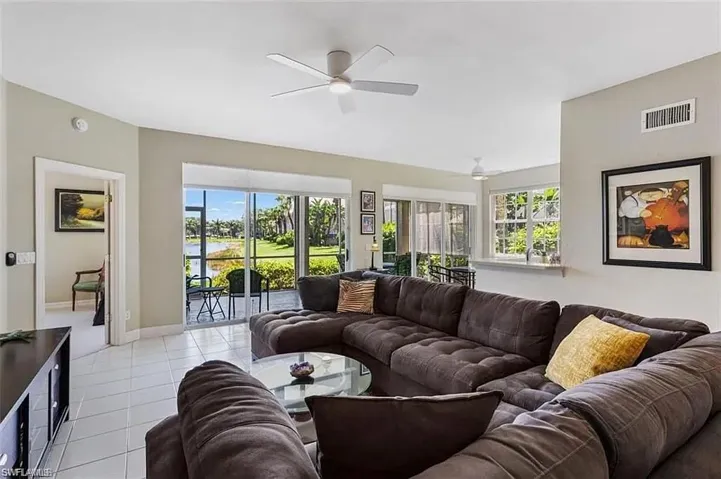 Tiled living room with plenty of natural light and ceiling fan