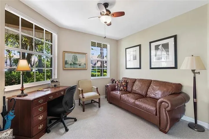 Home office with ceiling fan and light carpet