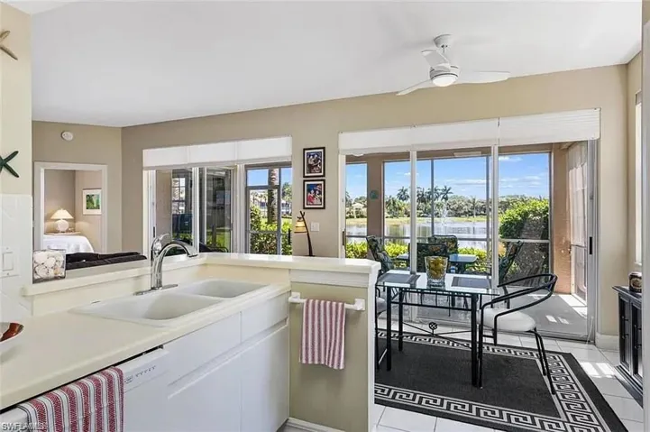 Kitchen with dishwasher, light tile patterned floors, sink, and ceiling fan
