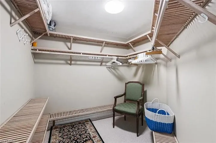 Bedroom with ceiling fan, connected bathroom, and light carpet