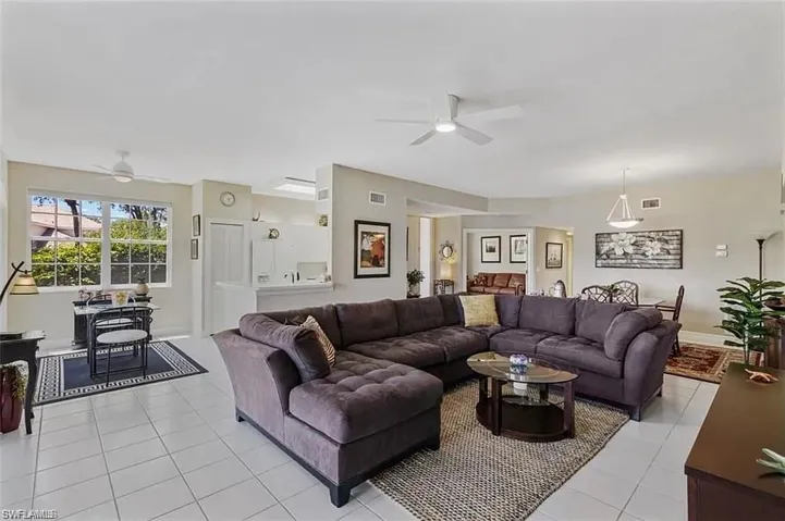 Living room with light tile patterned flooring and ceiling fan