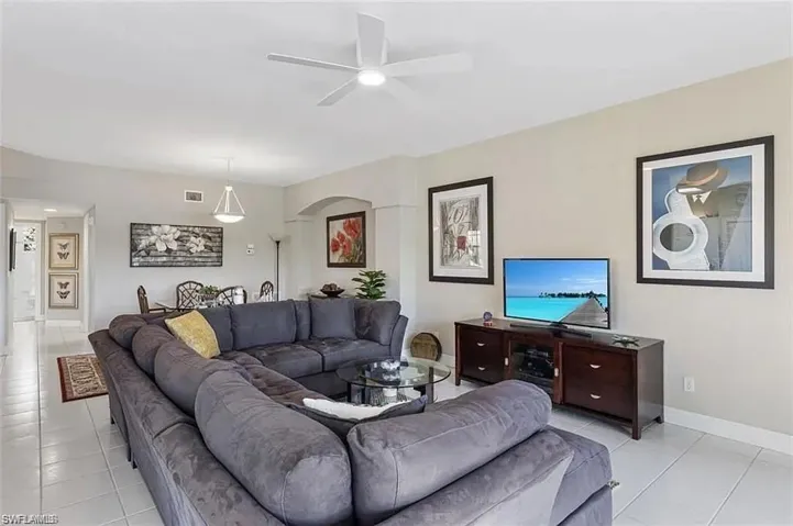 Living room with ceiling fan and light tile patterned floors
