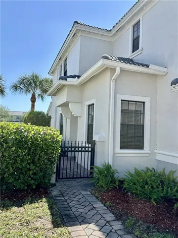 View of property exterior with a tile roof and stucco siding