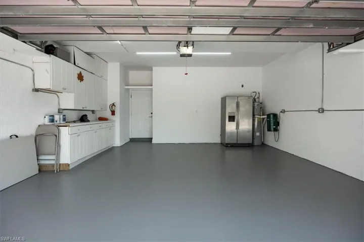 Freshly painted floors, built-in cabinetry and a side-by-side refridgerator/freezer.