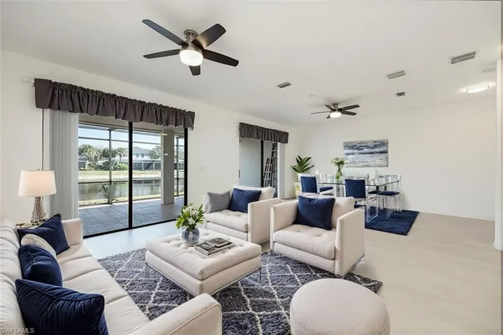 AI Staged - Living room with light wood-style floors, a water view, and visible vents