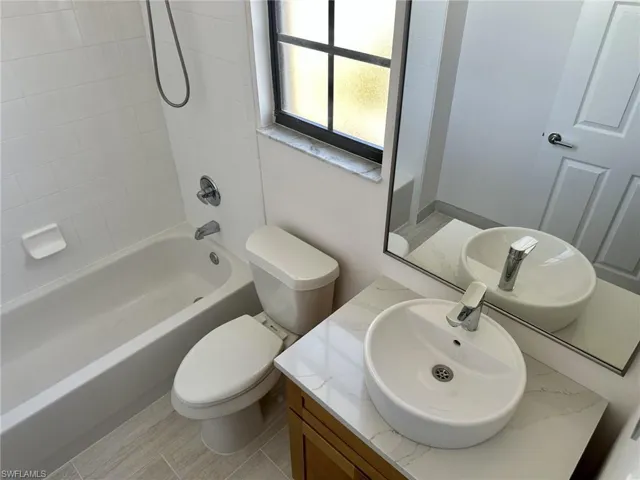 Bathroom with toilet, vanity, and shower / bath combination