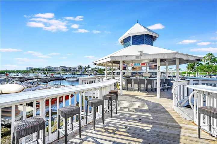 Dock area featuring a deck with water view, exterior bar, and a gazebo