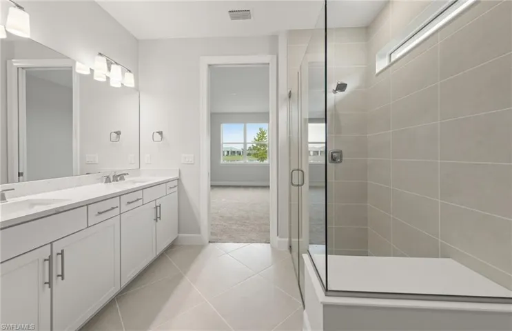 Bathroom with vanity, an enclosed shower, and tile patterned floors