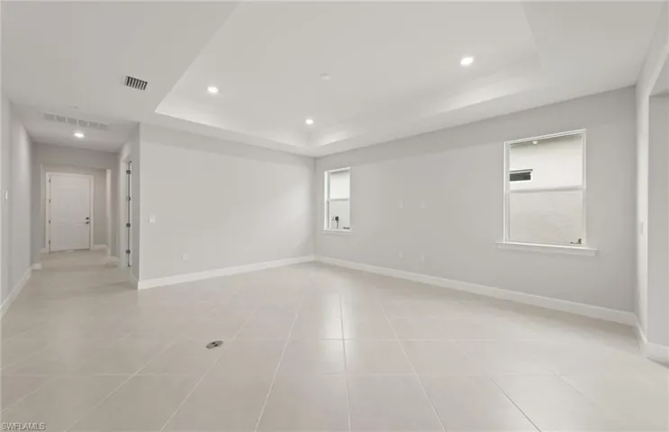 Spare room featuring a raised ceiling and light tile patterned flooring