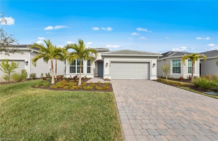 Ranch-style home featuring a garage and a front lawn