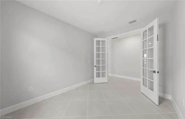 Unfurnished room with light tile patterned flooring and french doors