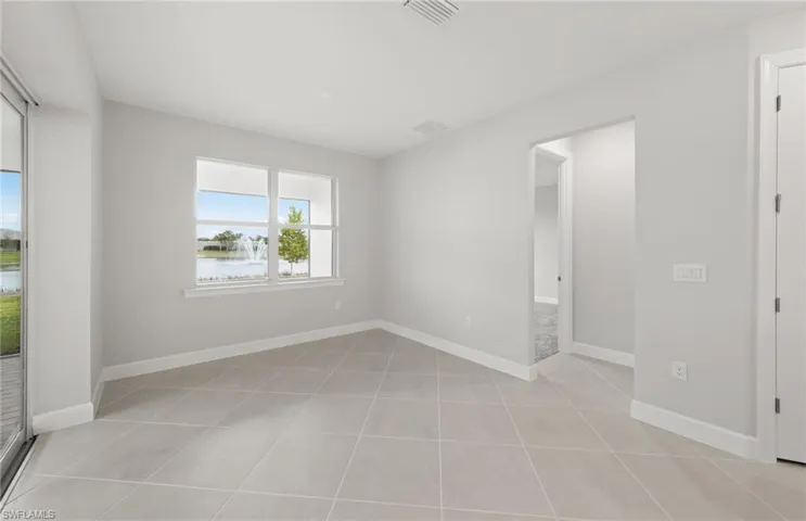 Spare room with light tile patterned flooring and a water view