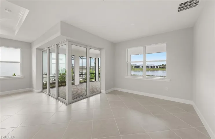 Empty room featuring a water view and light tile patterned flooring