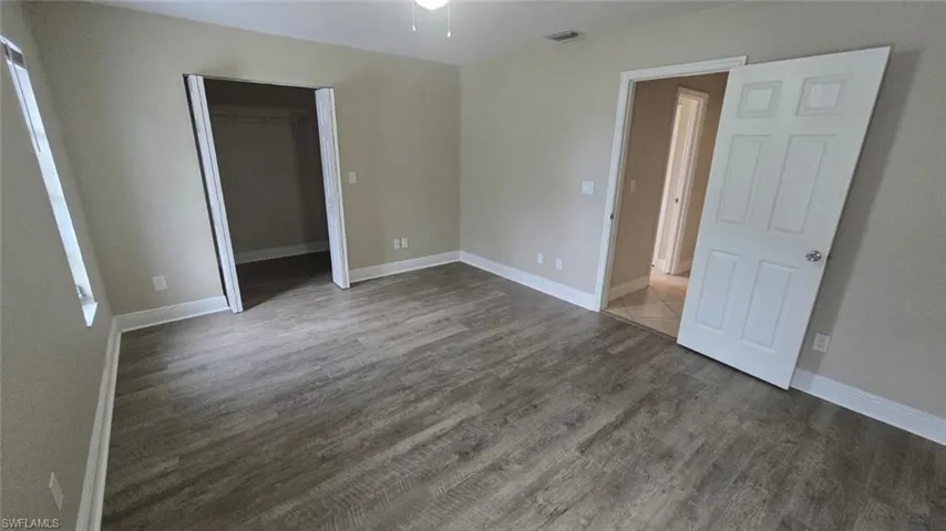 bedroom with dark wood-style flooring and a closet