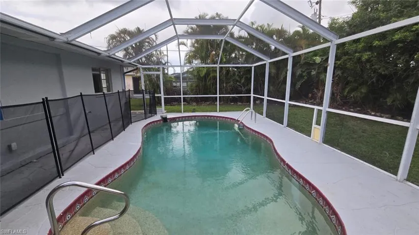 Swimming pool, enclosure, a lawn, and a patio area