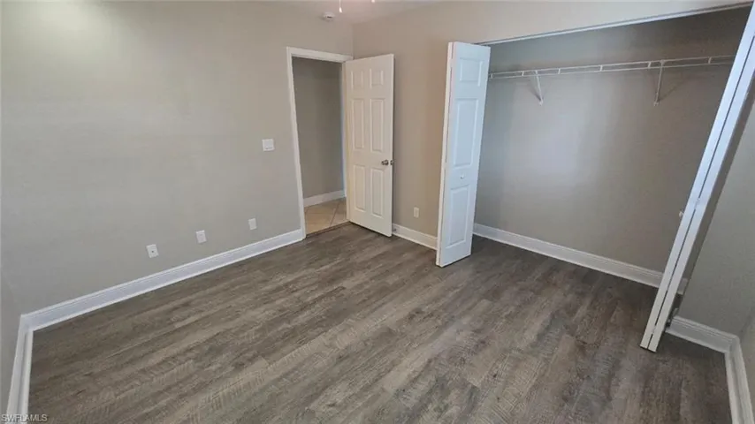 bedroom with a closet and dark wood-type flooring