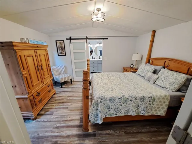 Bedroom featuring vaulted ceiling and hardwood / wood-style flooring