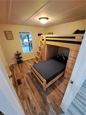 Bedroom with a textured ceiling and dark hardwood / wood-style floors