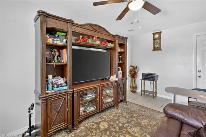Living room with ceiling fan and light tile patterned floors
