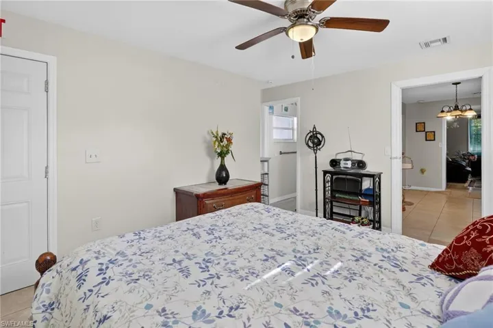 Bedroom with light tile patterned flooring, suspended lighting, and ceiling fan