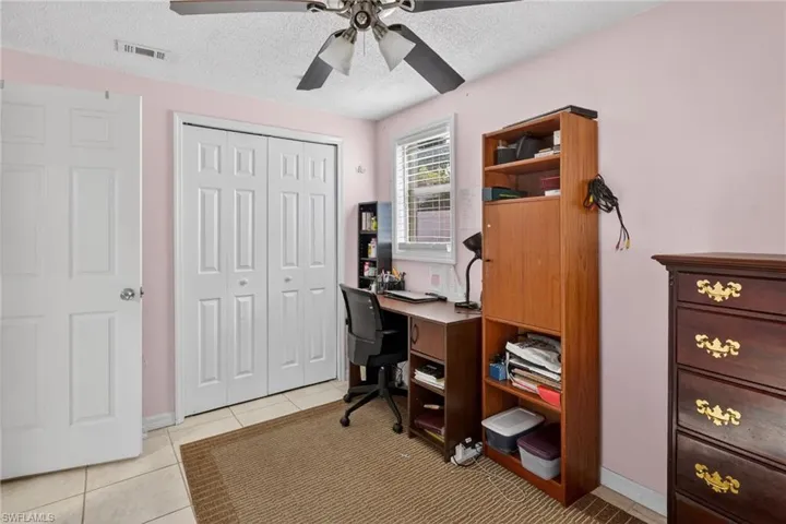 Home office featuring a textured ceiling, a ceiling fan, and light tile patterned floors