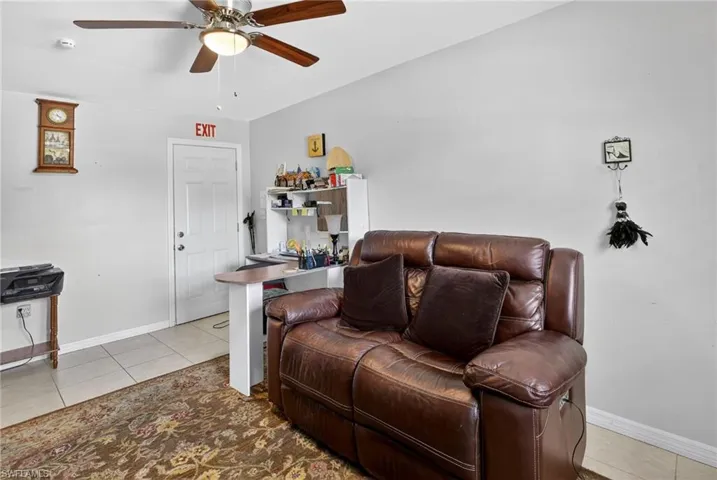 Living room with light tile patterned floors and ceiling fan