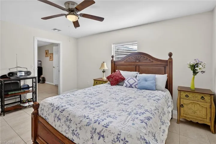 Bedroom with light tile patterned floors and a ceiling fan