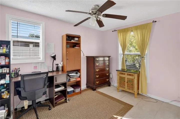 Office area featuring ceiling fan, a textured ceiling, healthy amount of natural light, and light tile patterned floors