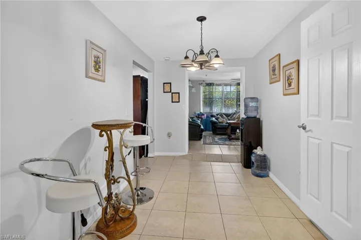 Hallway with light tile patterned floors and hanging lights